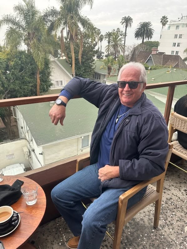 J.L. Best, smiling outdoors in sunglasses and a dark jacket — the same J.L. you know from Facebook